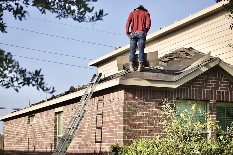 Professional roofer working on a residential roof in Independence Heights